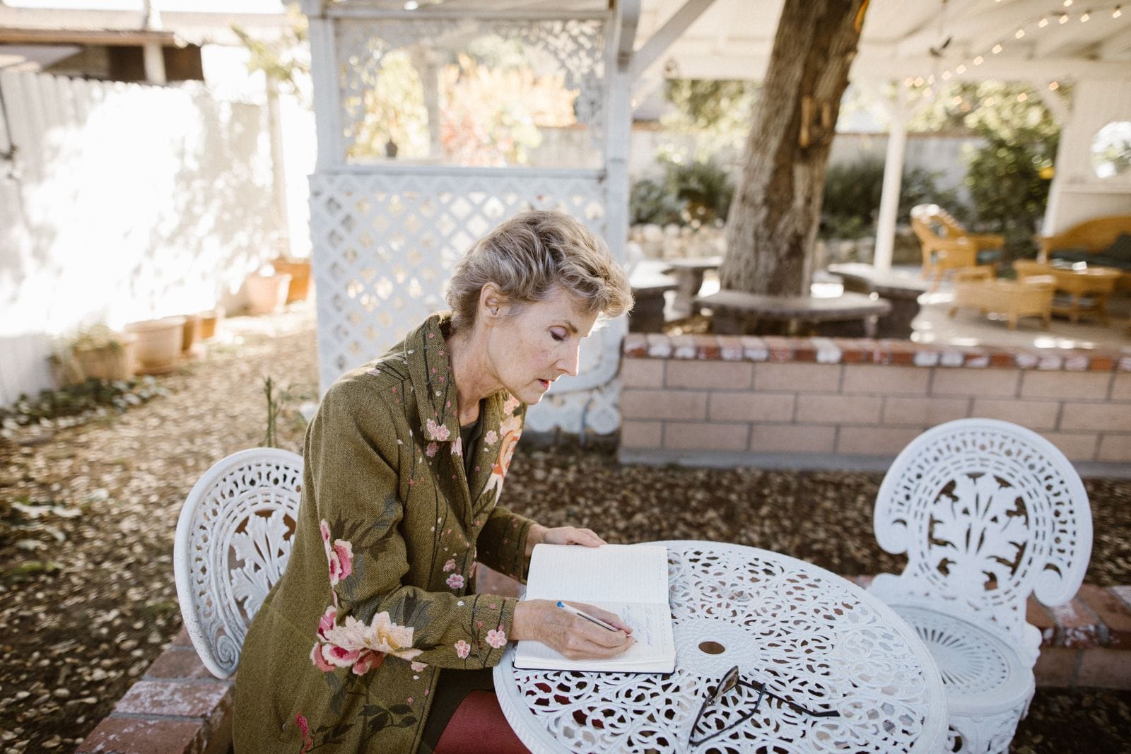 Senior woman writing notes at an outdoor table