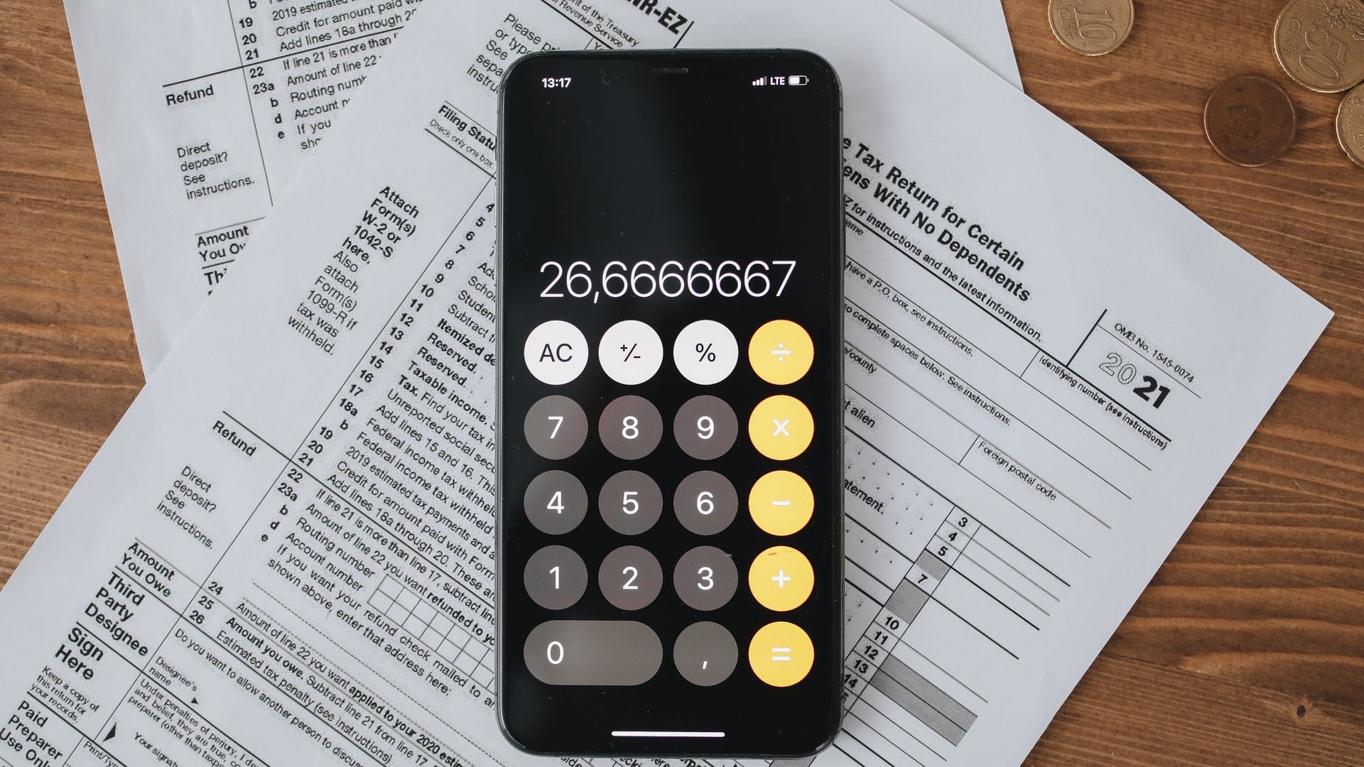 Calculator and tax forms arranged on a wooden desk