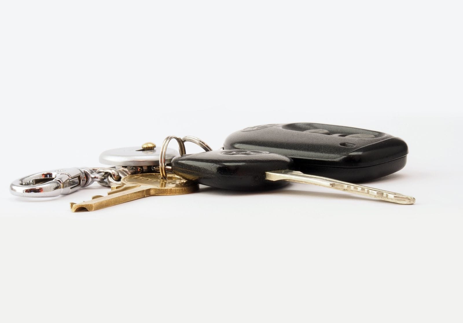 Pair of car keys on a white surface.