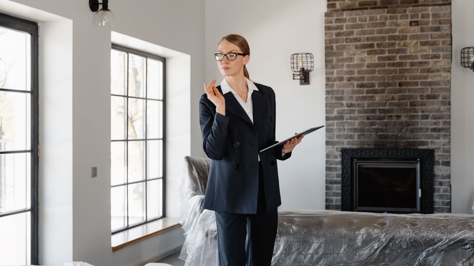 Woman using a tablet while inspecting furniture in a modern home