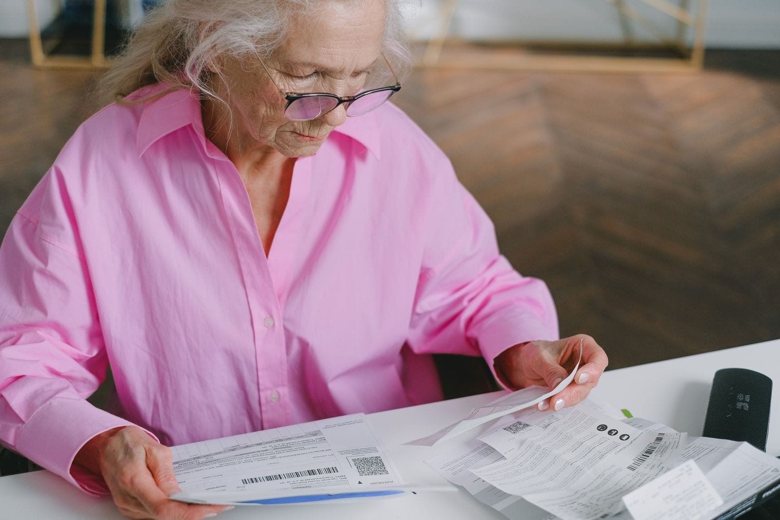 Older woman reading plan documents at a table