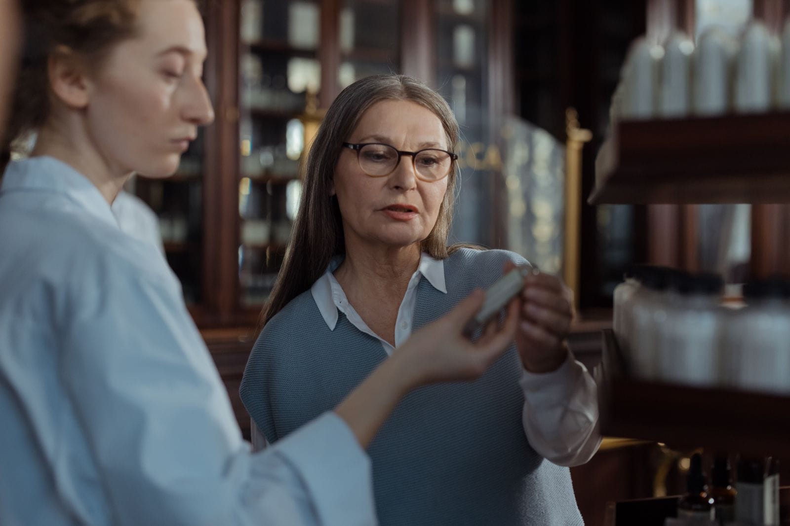 Older woman discussing medication options with a pharmacist