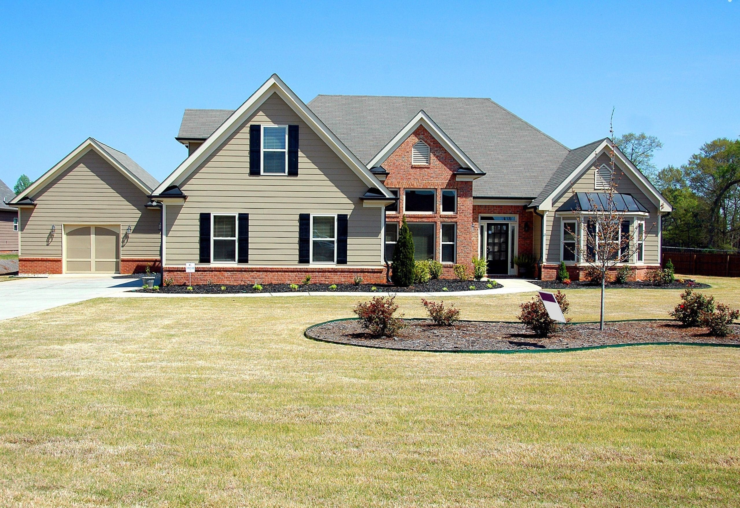 Detached home with brick exterior, garage and lawn
